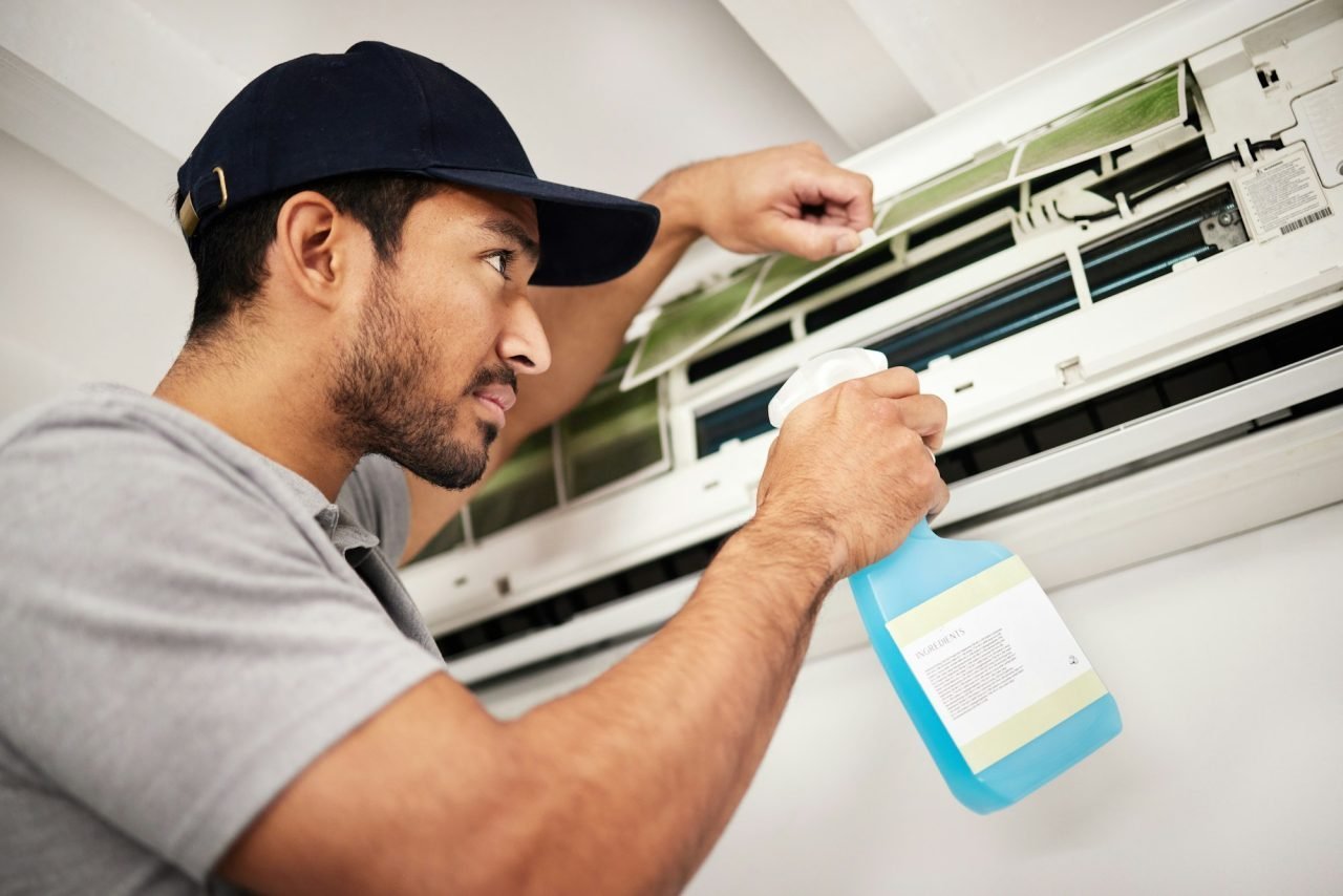 air-conditioner-cleaning-and-man-with-electrical-machine-check-in-a-home-with-ac-repair-maintenan